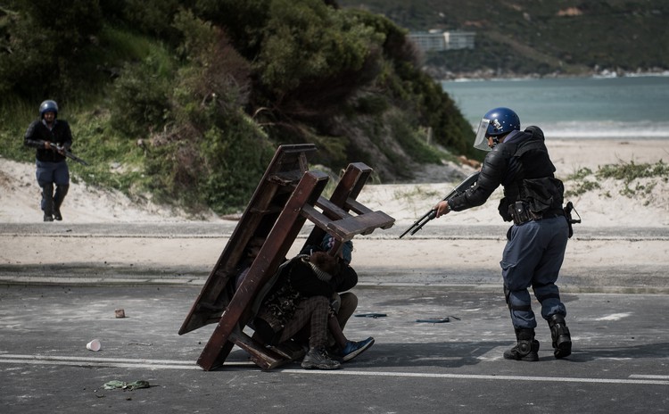 Photo of police office pointing rifle