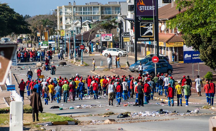 Photo of a street with workers in red tops