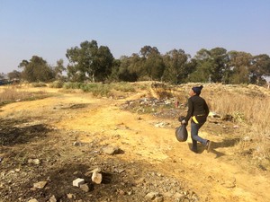 Photo of a man walking with a black dustbin bag