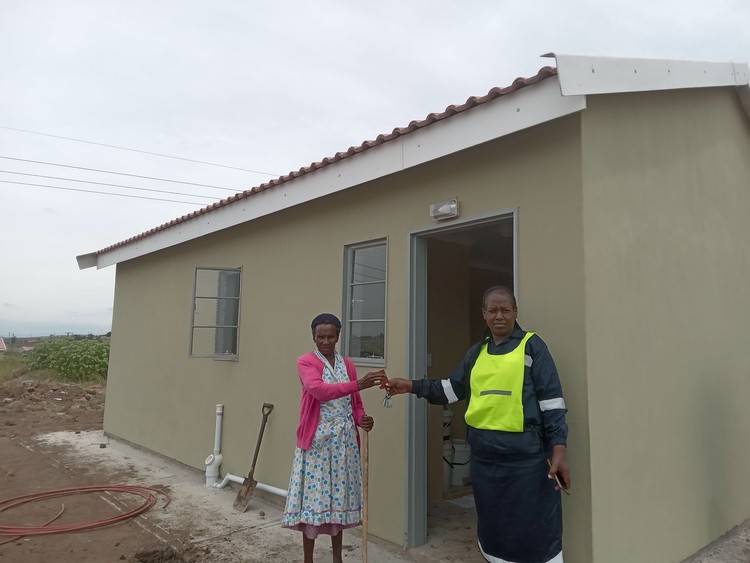 Photo of two women in front of a house