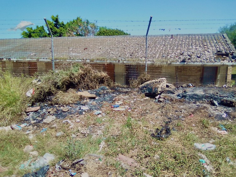 Photo of a school building and burnt remains 