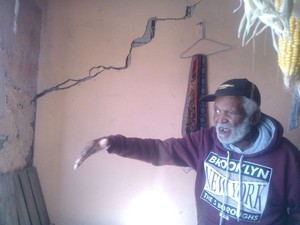 Photo of man pointing out crack in the wall