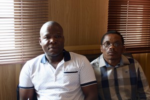 Photo of two men sitting side by side