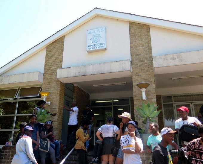 Photo of students outside a police station.