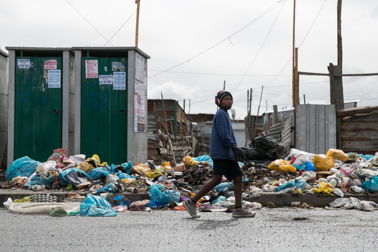 Photo of youth walking passed rubbish