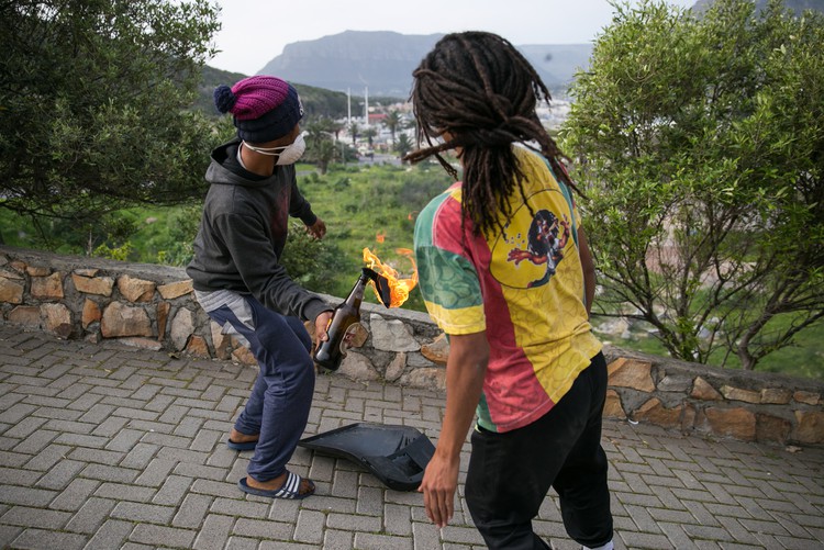 Photograph of protesters throwing a petrol bomb at riot police.