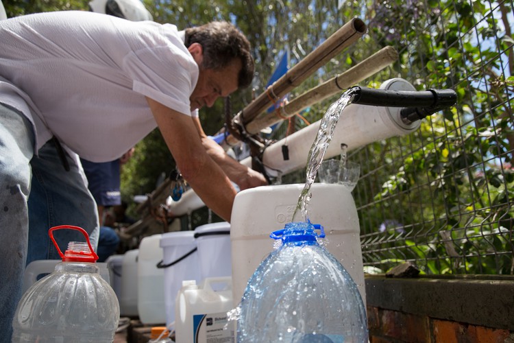 Photo of man collecting water at Newlands Spring