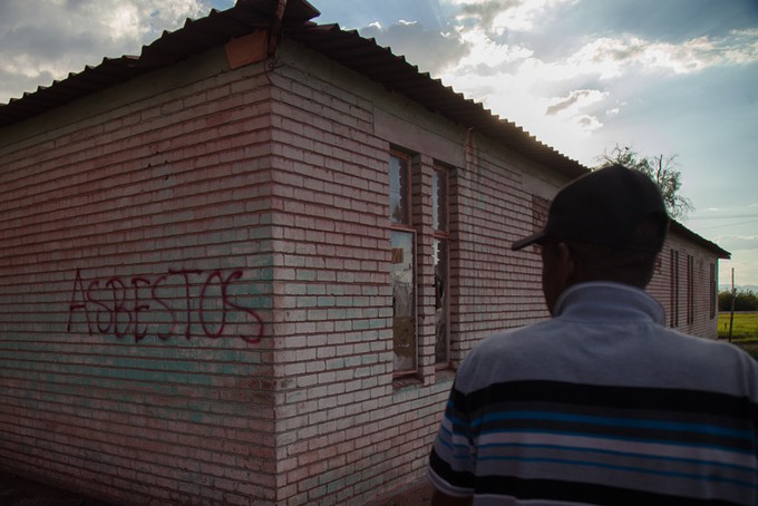 Photo of abandoned house with \"asbestos\" written on it