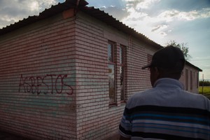 Photo of abandoned house with "asbestos" written on it