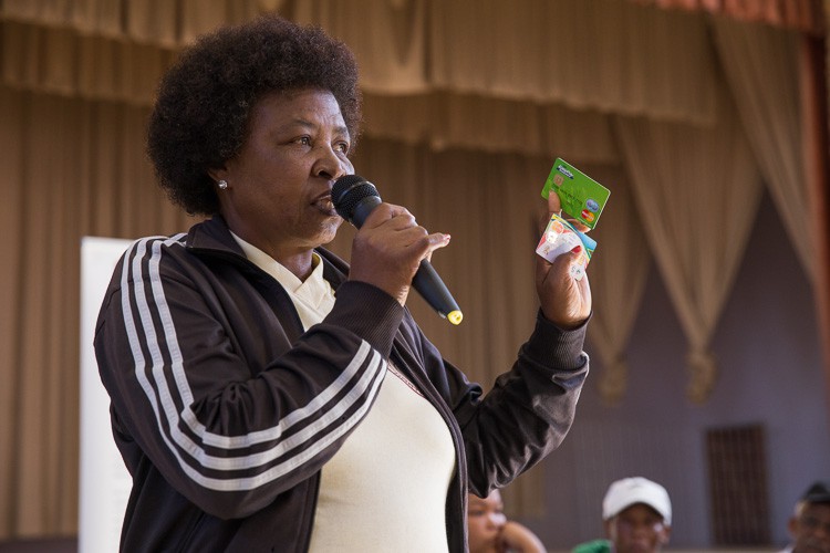 Photo of woman holding Net1 green card