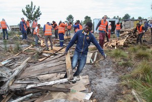 Phot of man carrying materials with people behind him