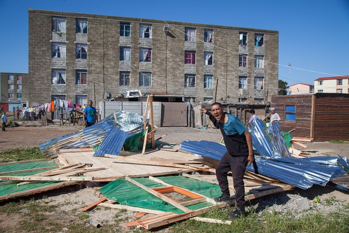 Man pointing to demolished house