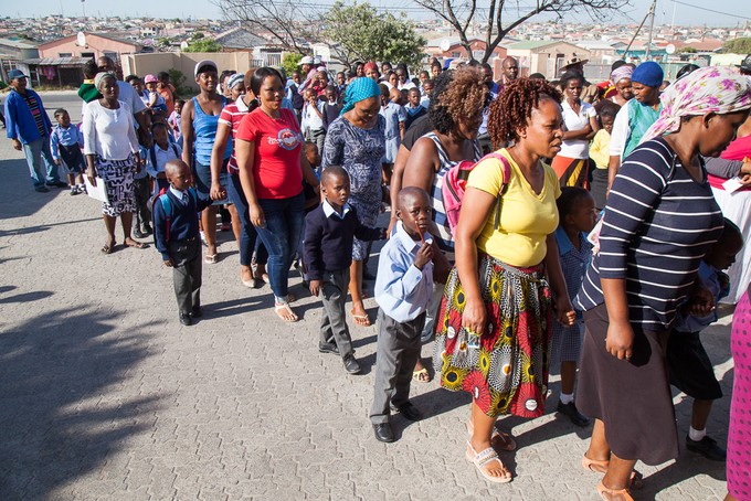 Photo of parents and child standing in line to start school