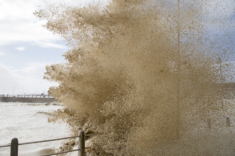 Photo of wave crashing onto promenade