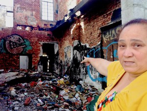 Photo of woman pointing to a burn out building