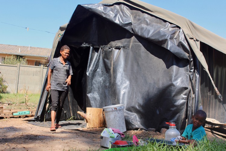 Photo of a woman and child outside a tent