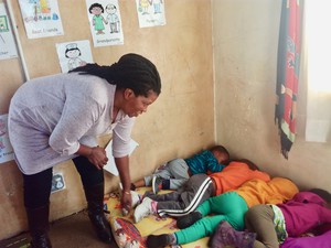 Photo of a woman and a row of sleeping children