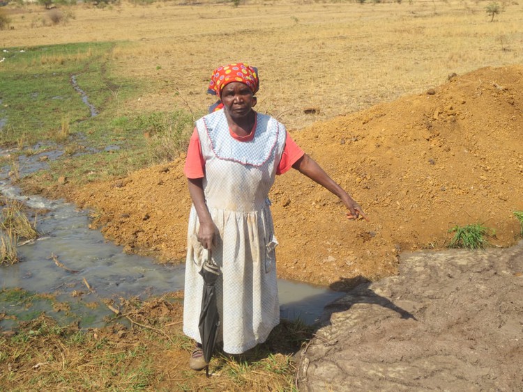 Photo of woman pointing to sewerage leak