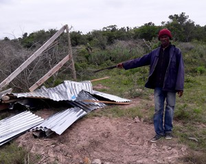 Photo of a man and a demolished shack