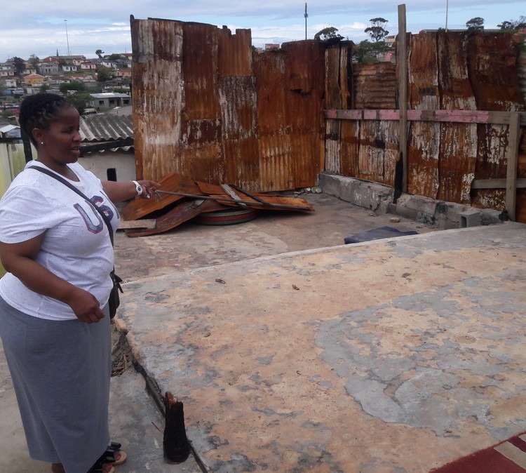 Photo of a woman showing a burnt shack