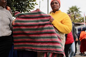 Photo of a woman holding up a blanket