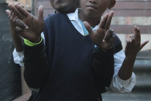 Photo of two men doing gang salute