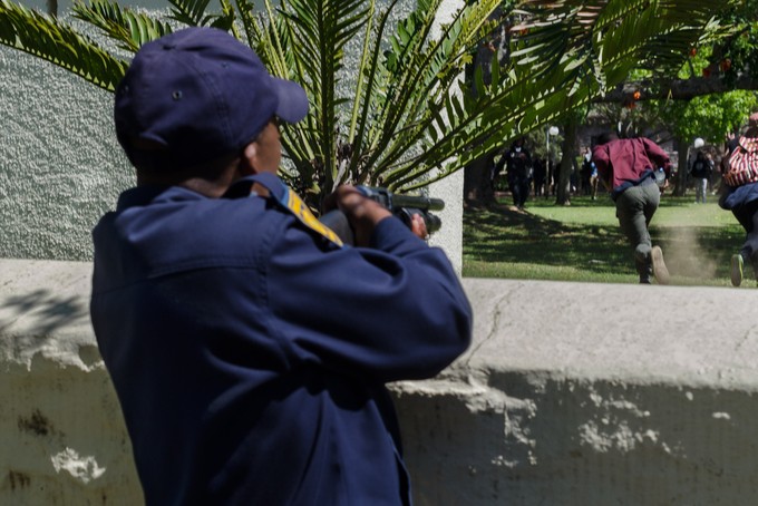 Photo of cop shooting at fleeing protesters