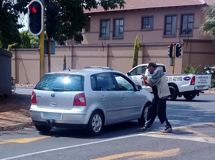 Photo of man begging from car