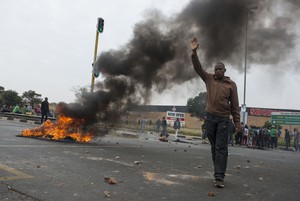 Photo of man trying in front of burning rubble