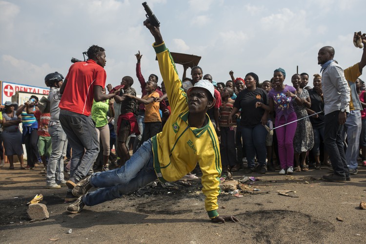 Photo of man with toy gun in front of crowd