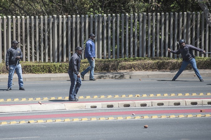 Photo of woman being escorted off campus