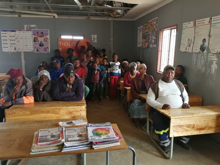 Photo of parents in school classroom with broken ceiling