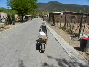 Photo of a man pushing a wheelbarrow