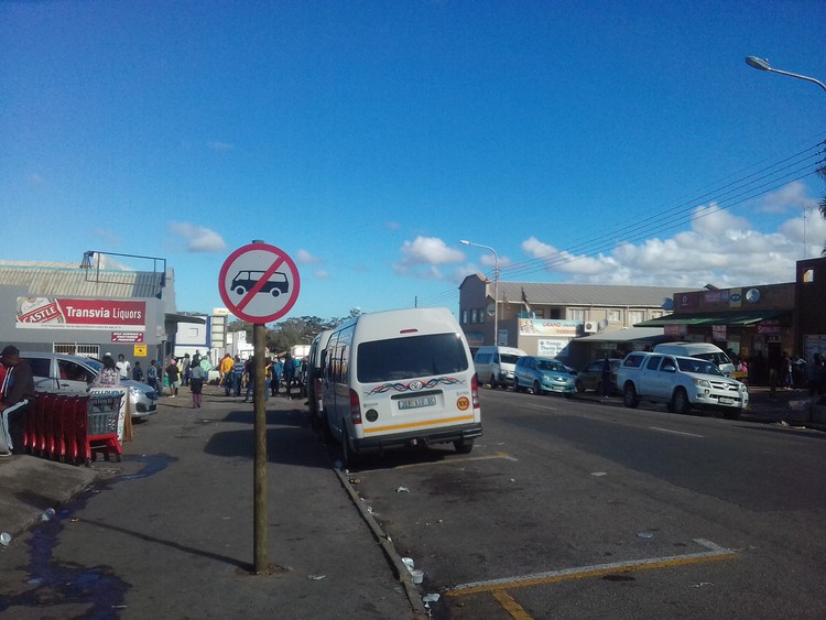 Photo of taxi in road under \"no taxis\" sign