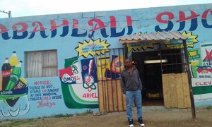 Photo of man standing outside colourful shop