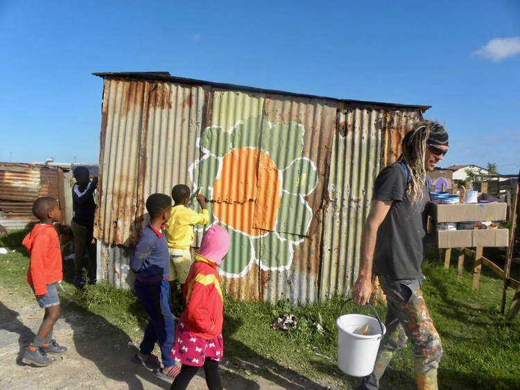 Photo of people painting a shack