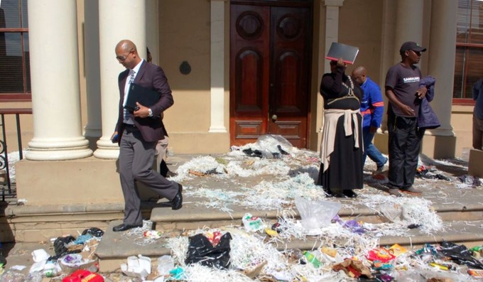 Photo of people stepping over rubbish