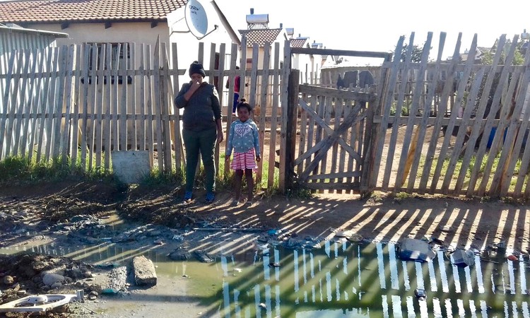 Photo of two people in a flooded yard