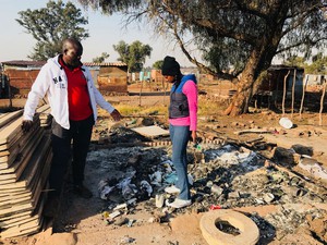 Photo of two people on burnt shack