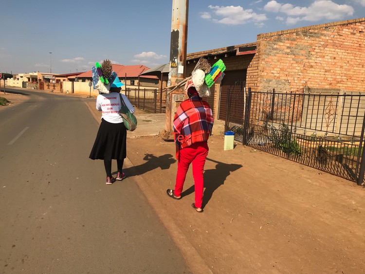 Photo of two women carrying brooms