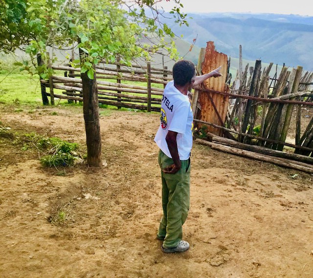 Photo of a man pointing to mountains in the distance