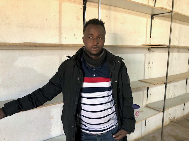 Photo of a man in front of bare shelves