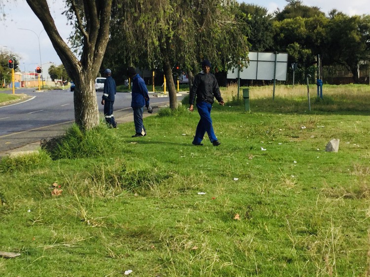 Photo of men waiting on the side of the road for work