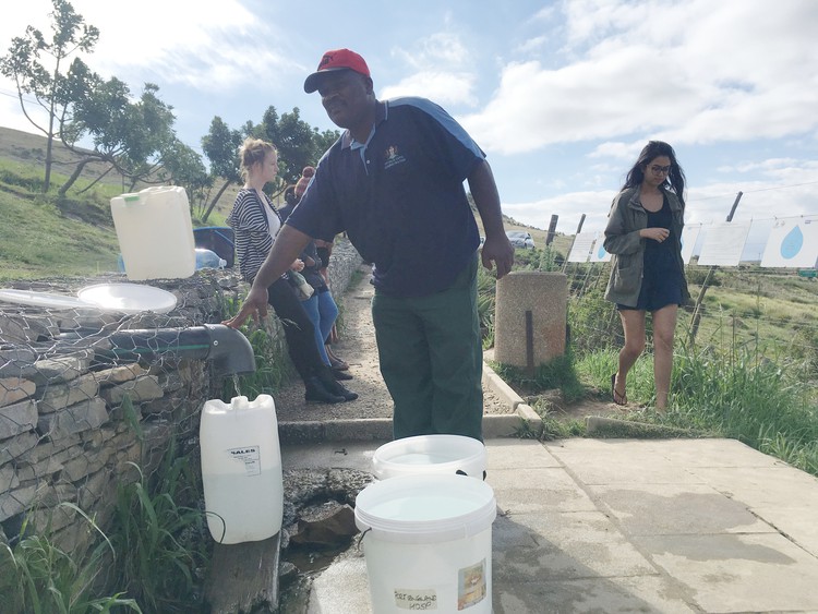 Photo of man collecting water from spring