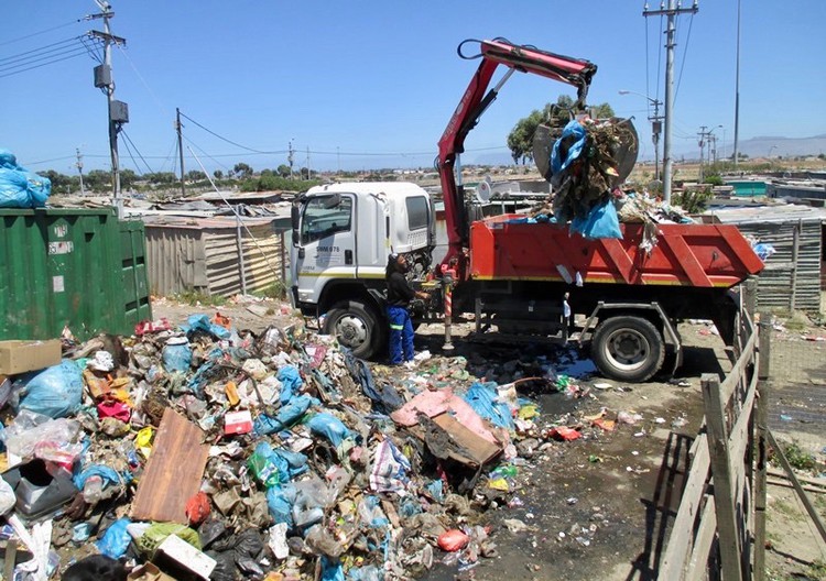 Photo of truck with crane loading rubbish