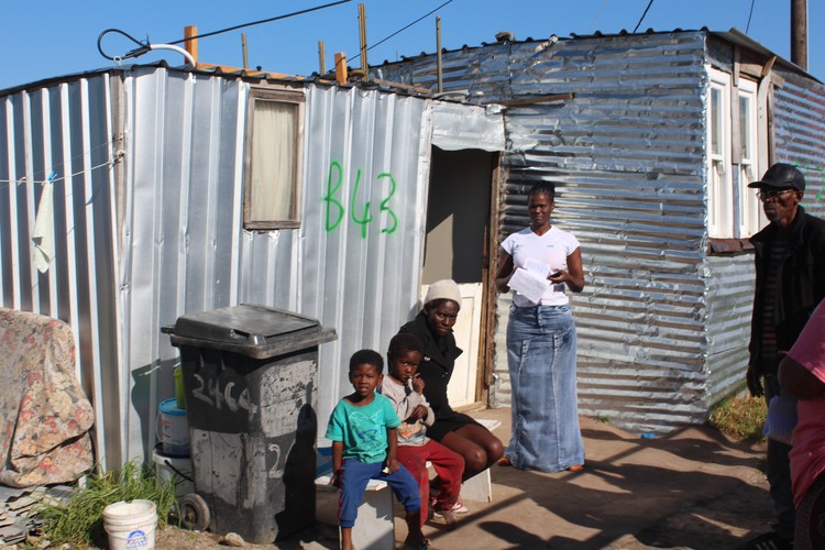 Photo of woman in front of shack