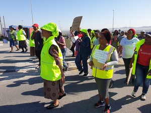 Photo of people in yellow bibs marching