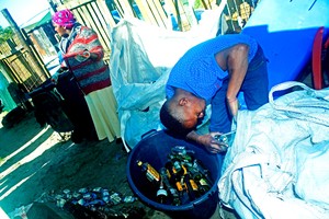 Photo of two people recycling bottles