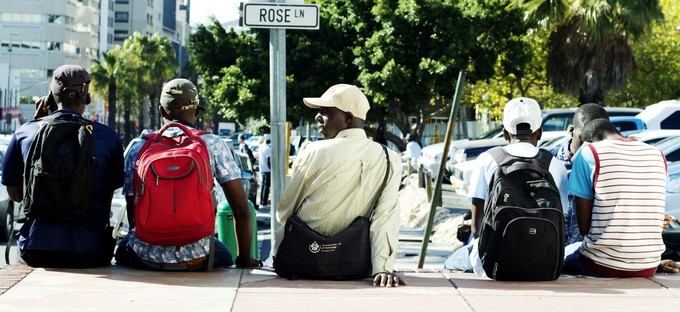 Photo of men sitting at side of road waiting for work