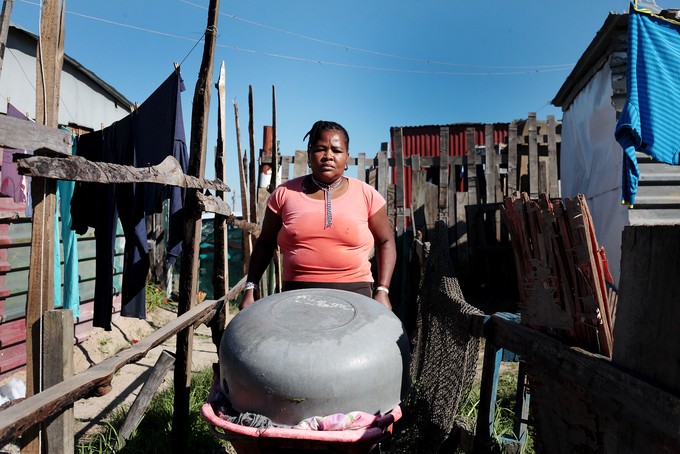 Woman walking with wheelbarrow full of washing